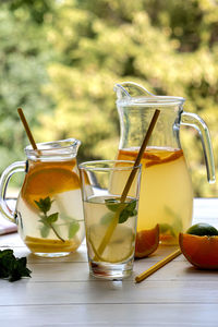 Preparation of lemonade drink. lemonade in a jug and lemon and lime and mint