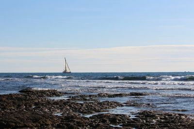 Sailboat sailing on sea against sky