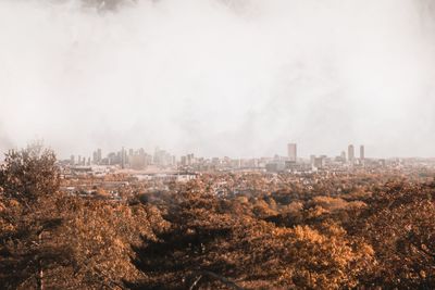 Aerial view of buildings in city against sky