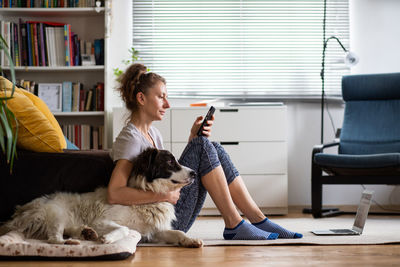 Woman with dog sitting at home