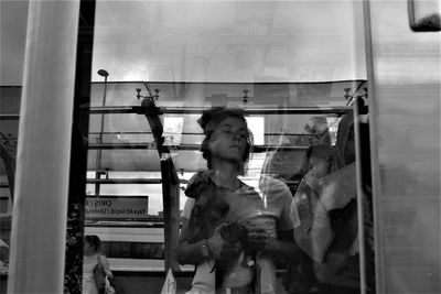 Full length of boy standing in glass window