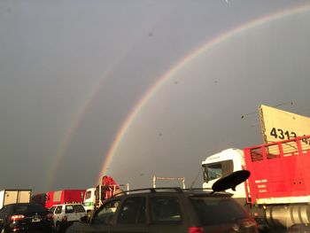 Rainbow over city against sky