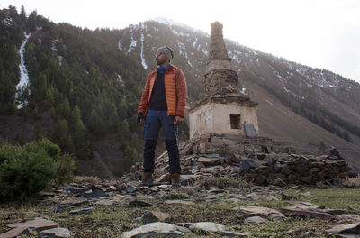 Full length of man standing on rock against sky