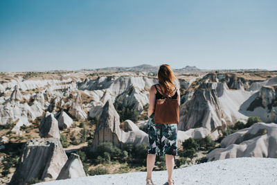 Rear view of woman looking at rock formations