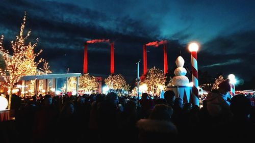 Crowd at music concert against sky at night