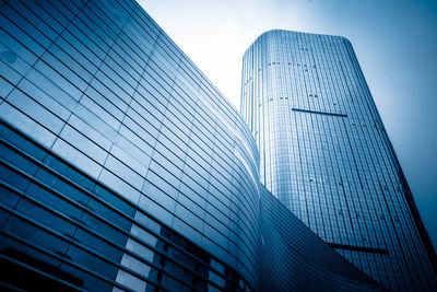 Low angle view of modern glass building against sky