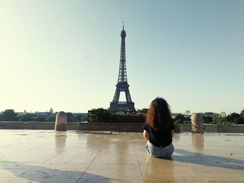 Rear view of woman looking at eiffel tower against clear sky