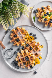 Breakfast with waffles with blueberries and syrup on a plates