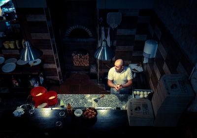 High angle view of chef looking away while cooking in commercial kitchen