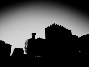 Low angle view of silhouette buildings against sky