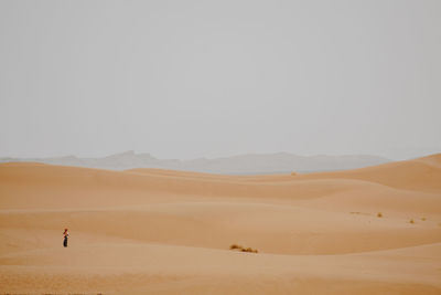 Man standing on desert against sky