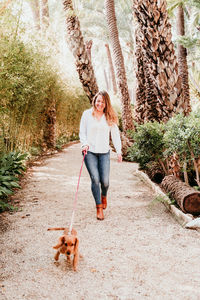 Dog with woman on footpath at park