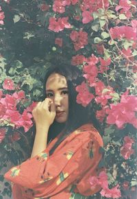 Portrait of young woman with red flower plants