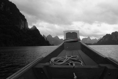 View of boat in lake against cloudy sky