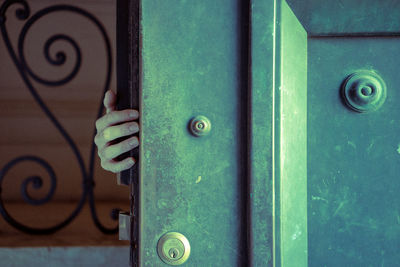 Cropped hand holding green door