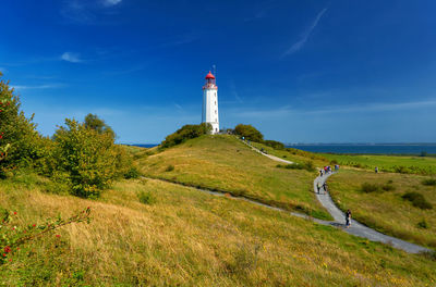Lighthouse on landscape against sky