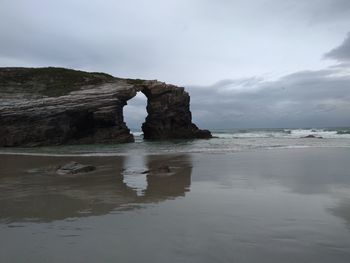 Rock formation in sea against sky