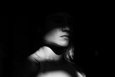 Close-up portrait of young woman in darkroom