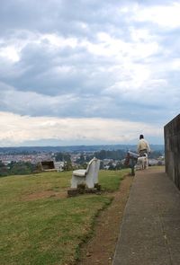 Statue in park against cloudy sky