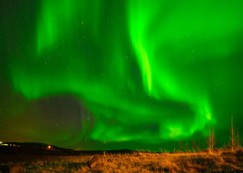 Scenic view of illuminated landscape against sky at night