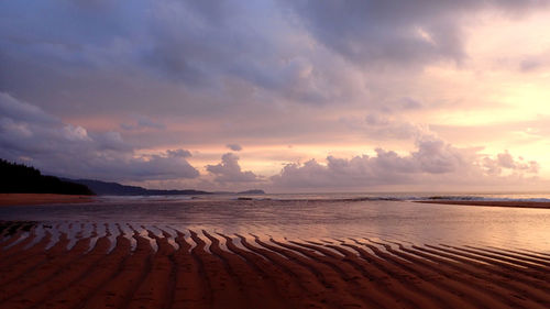 Scenic view of beach against sky during sunset