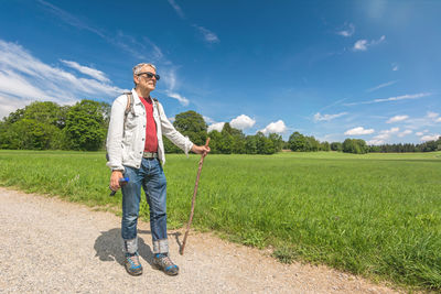 Full length of man standing on field against sky