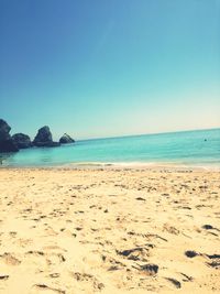 Scenic view of beach against clear blue sky