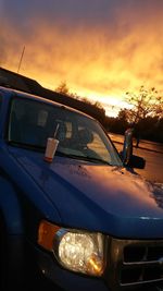 Close-up of car against sky during sunset