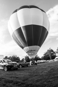 Hot air balloons on field against sky