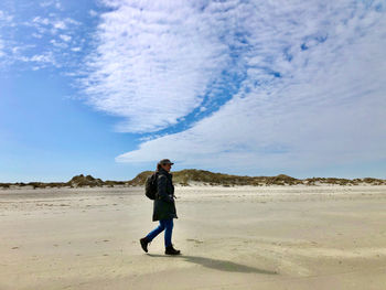 Full length of man standing on beach against sky