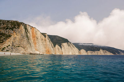 Scenic view of sea and mountains against sky