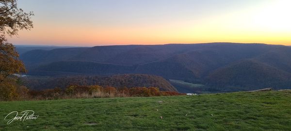 Scenic view of field against sky during sunset