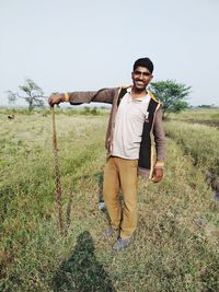 Portrait of young man standing on field