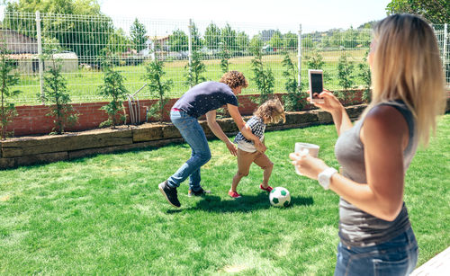 Boys playing soccer on field at park