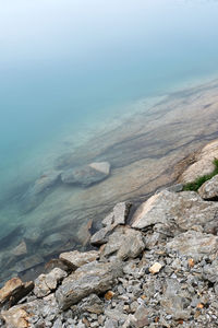 Scenic view of rocks on beach against sky