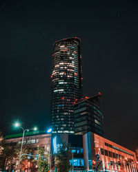 Low angle view of illuminated buildings against sky at night