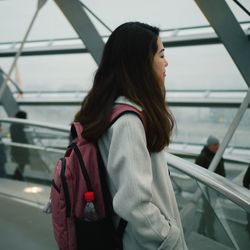 Rear view of woman standing by railing