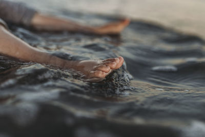 Detail view of young child toes in water at beach