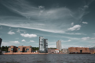 View of cityscape against cloudy sky