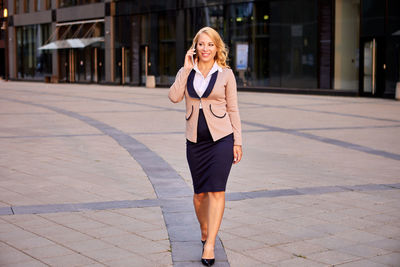 Full length of businesswoman walking on street