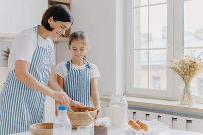 Mother and daughter preparing food at home