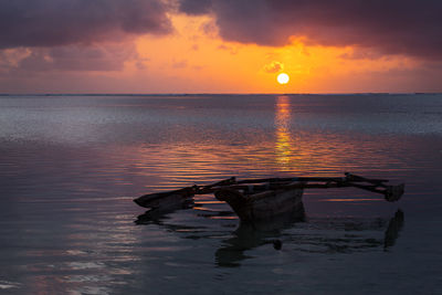 Scenic view of sea with boat against sky during sunset