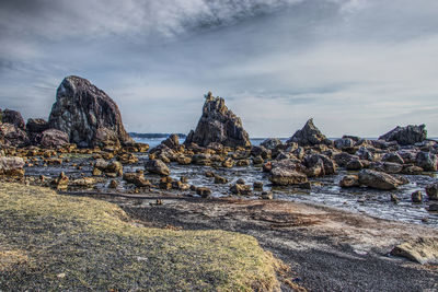Panoramic shot of rocks on beach against sky