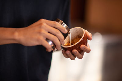 Midsection of man holding coffee cup