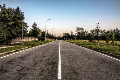 Road by trees against sky