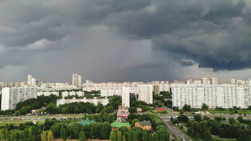 Buildings in city against cloudy sky