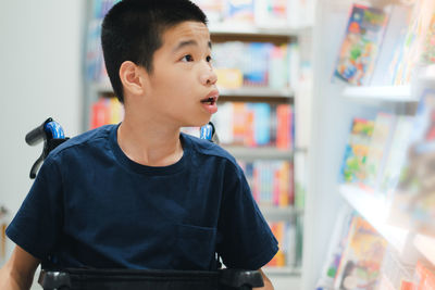 Boy looking away while standing in store