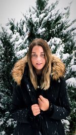 Portrait of young woman standing in snow