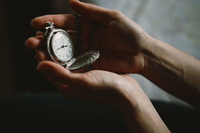 Cropped hand of person holding pocket watch