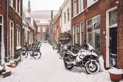 Bicycles parked on street amidst buildings during winter